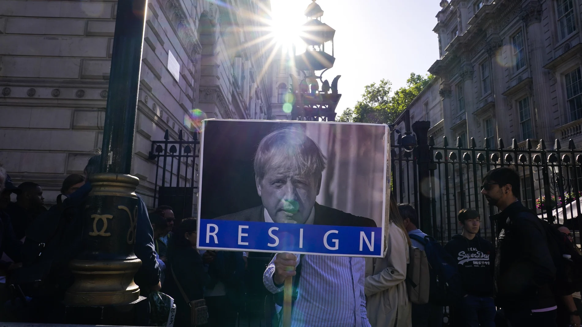 Una manifestante sostiene un cartel pidiendo la dimisión de Boris Johnson a la puerta de Downing Street
