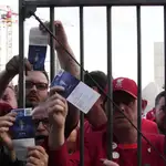 Seguidores del fútbol enseñan sus entradas en las puertas del Estadio de Francia en París
