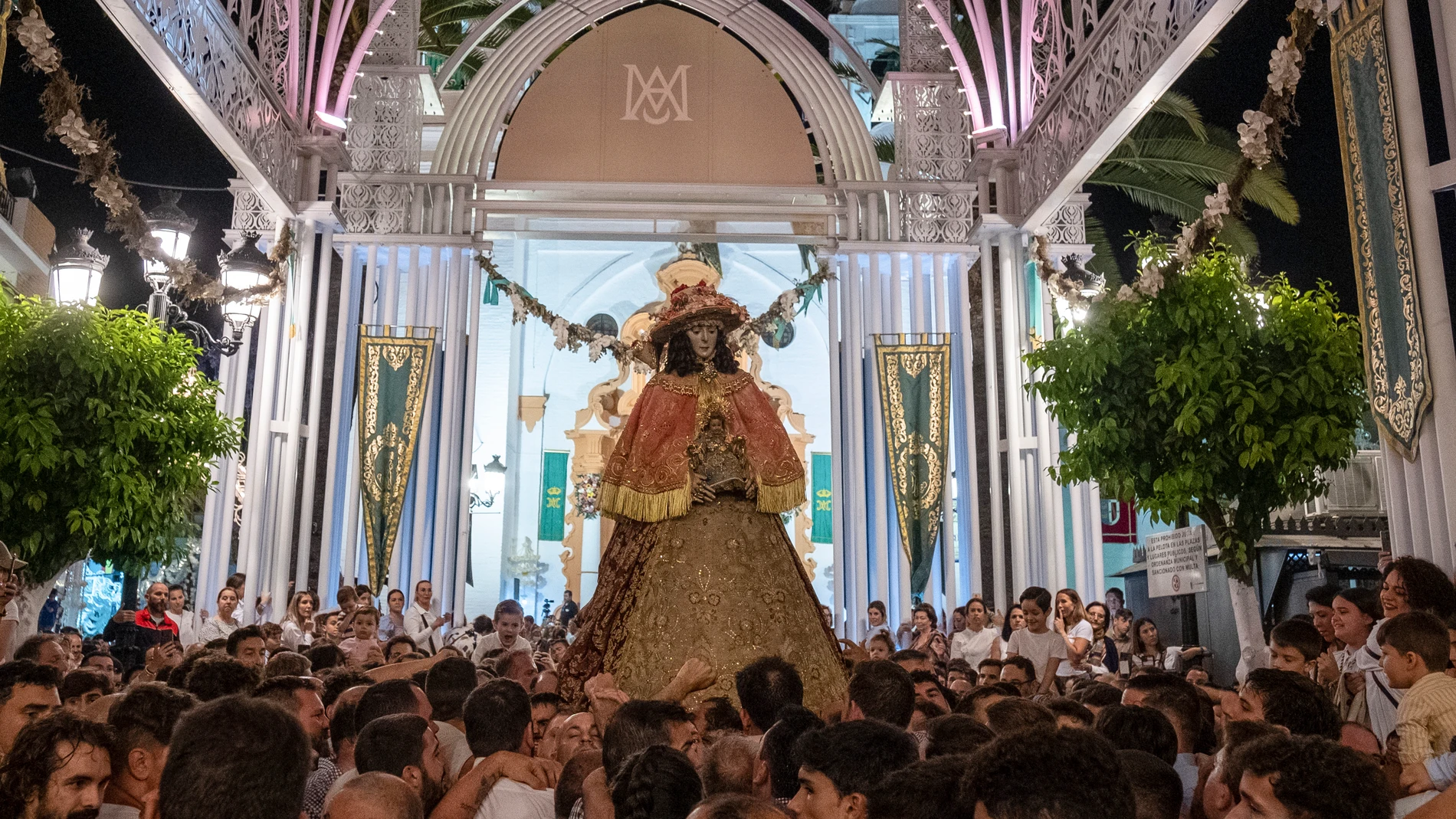 La virgen del Rocío, vestida de Pastora, procesiona a hombros de los almonteños por las calles de Almonte (Huelva). EFE / Julián Pérez.