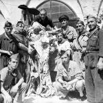 Un grupo de milicianos posan con la momia que han sacado de la tumba de un monasterio. La profanación estaba a la orden del día