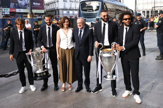 Modric, Nacho, Isabel Díaz Ayuso, Florentino Pérez, Benzema y Marcelo, con los trofeos de campeones de Liga y de la Liga de Campeones