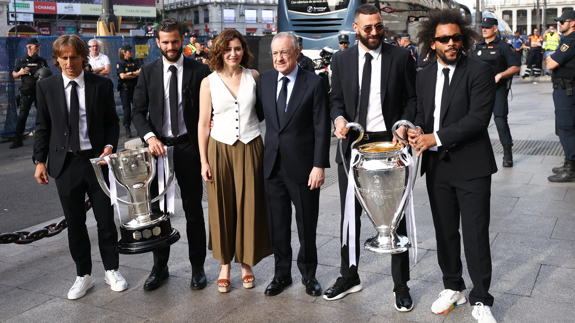 Modric, Nacho, Isabel Díaz Ayuso, Florentino Pérez, Benzema y Marcelo, con los trofeos de campeones de Liga y de la Liga de Campeones