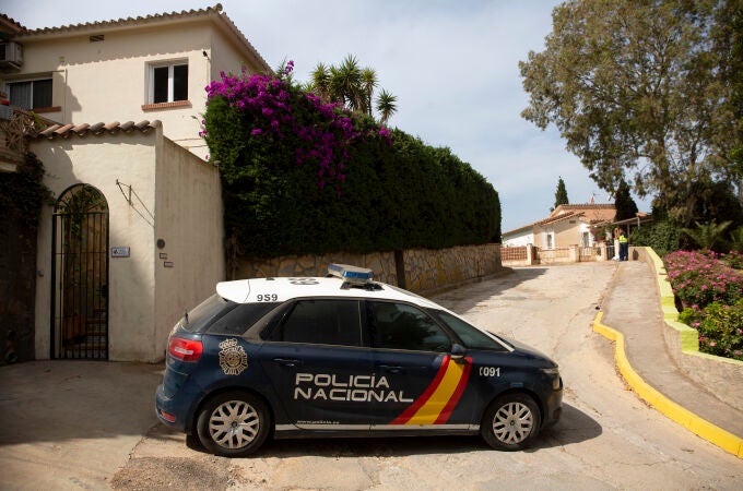 Miembros de la Policía Nacional vigilan la entrada a la vivienda donde una mujer de 50 años ha sido apuñalada de muerte esta madrugada, presuntamente a manos de su pareja, en Benajarafe (Málaga). EFE/Daniel Pérez