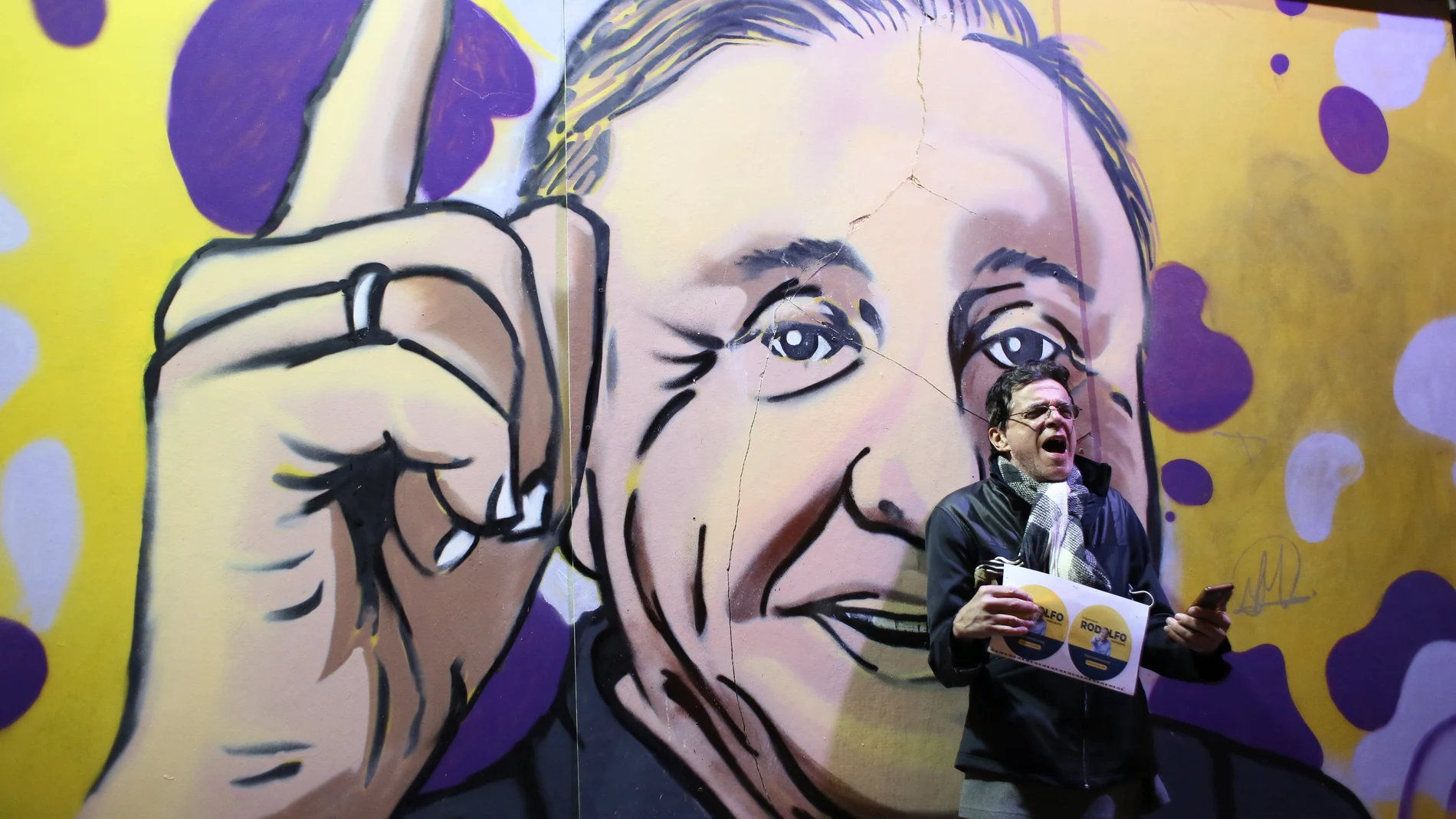 Un seguidor de Rodolfo Hernández junto a un cartel con el rostro del candidato colombiano