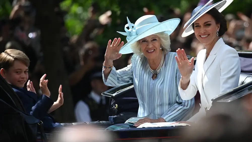 Las británicas Camilla (izq.), duquesa de Cornualles, y Catalina (dcha.), duquesa de Cambridge, saludan a los asistentes en el Palacio de Buckingham. EFE