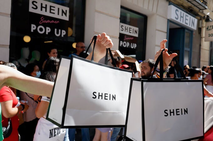 Dos personas sujetan dos bolsas después de entrar a la primera tienda física temporal de Shein en Madrid,el pasado 2 de junio