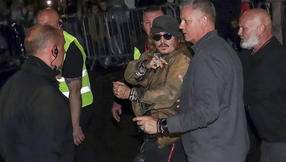 Johnny Depp, escoltado a la salida de un concierto en Gateshead. (AP Photo/Scott Heppell)