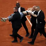 Los miembros de seguridad se llevan en volandas a la activista que se coló en la semifinal de Roland Garros entre Ruud y Cilic