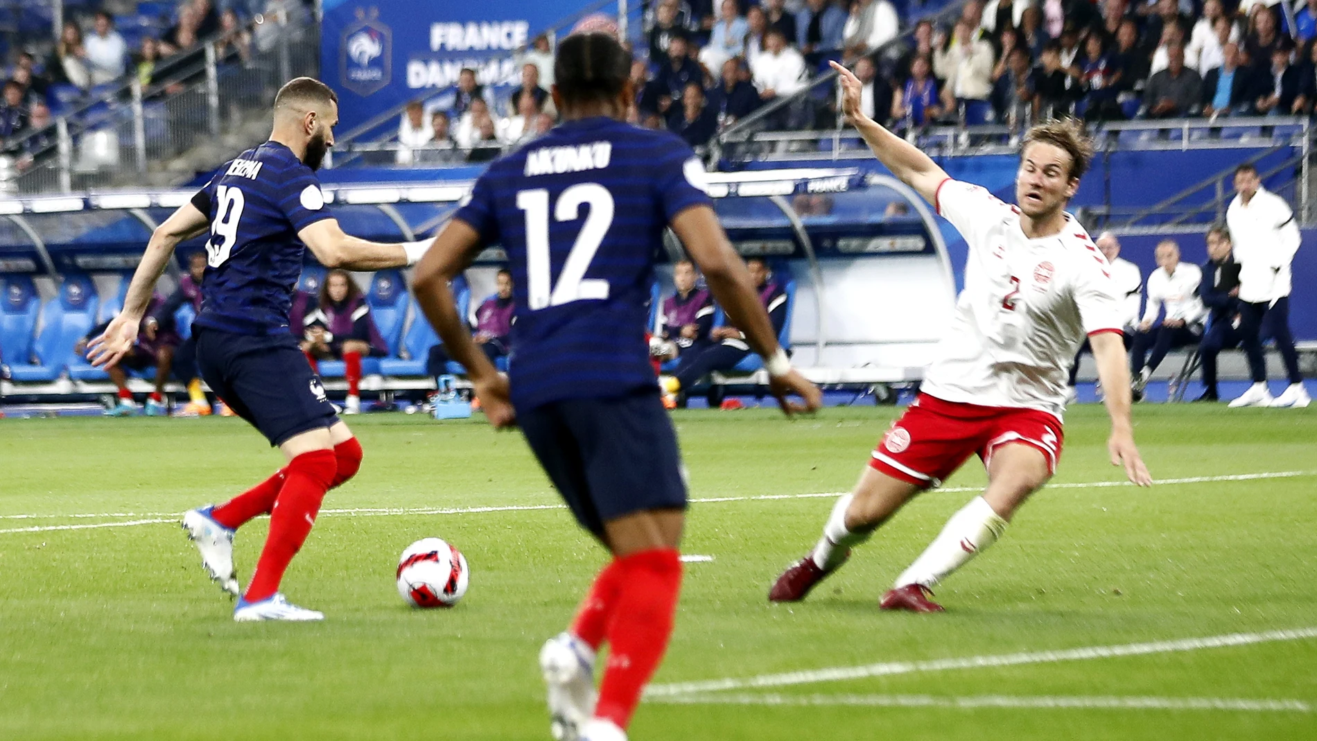Karim Benzema recorta y envía al suelo a un defensa de Dinamarca antes de marcar el primer gol del partido