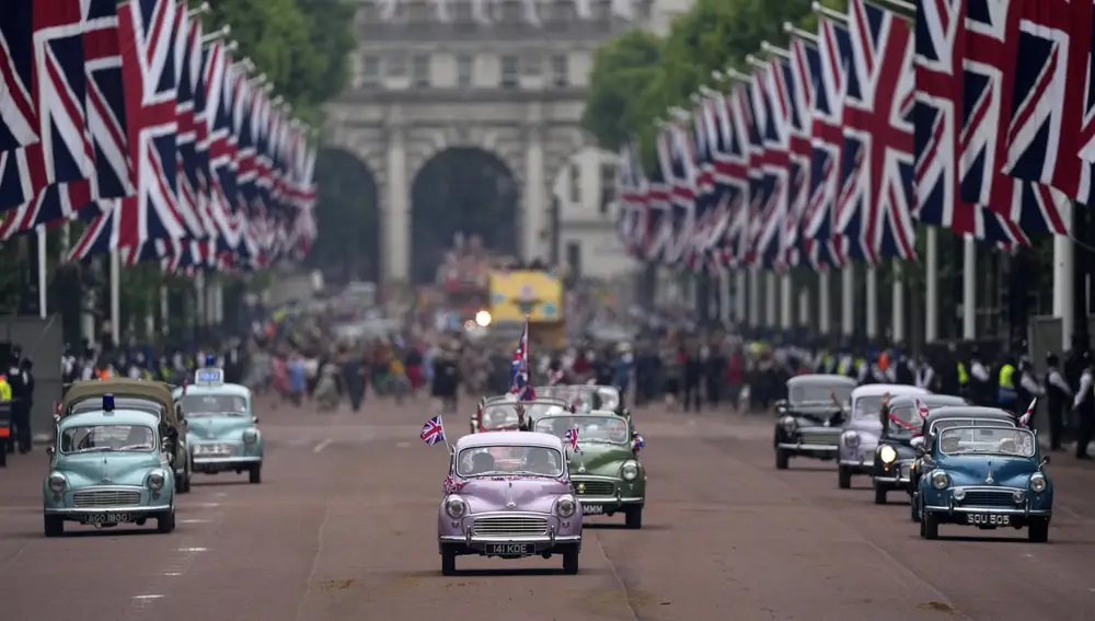 Drivers with old cars parade during the Platinum Jubilee Pageant outside Buckingham Palace in London, Sunday, June 5, 2022, on the last of four days of celebrations to mark the Platinum Jubilee. The pageant will be a carnival procession up The Mall featuring giant puppets and celebrities that will depict key moments from the Queen Elizabeth II's seven decades on the throne. (AP Photo/Frank Augstein, Pool)