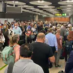 Decenas de pasajeros hacen cola en el aeropuerto de Barajas ayer para acceder al control de pasaportes