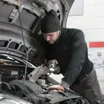Mecánico en su taller revisando un vehículo
