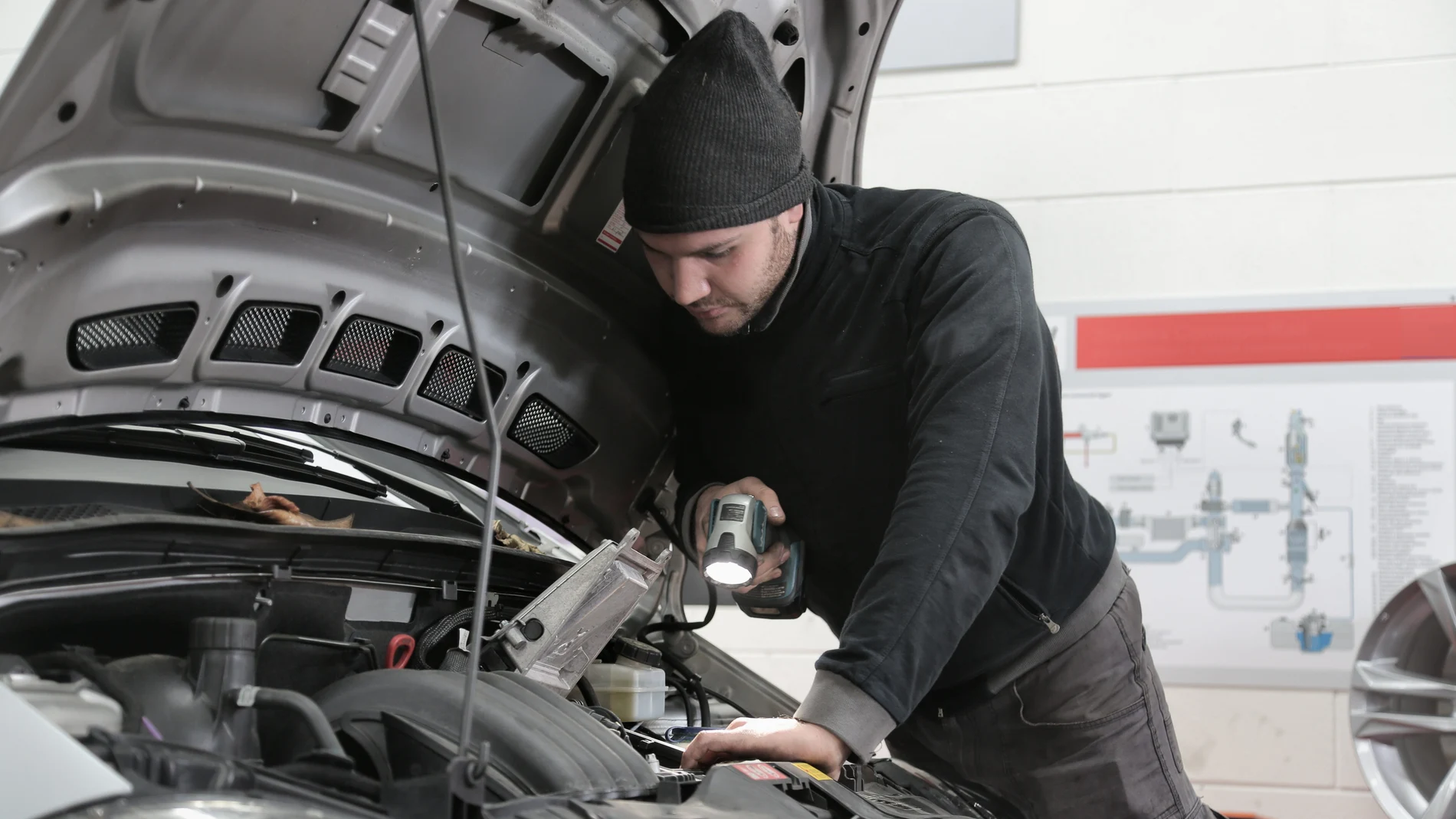 Mecánico en su taller revisando un vehículo