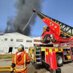 Once dotaciones de bomberos tratan de sofocar el fuego en una nave industrial de Paterna