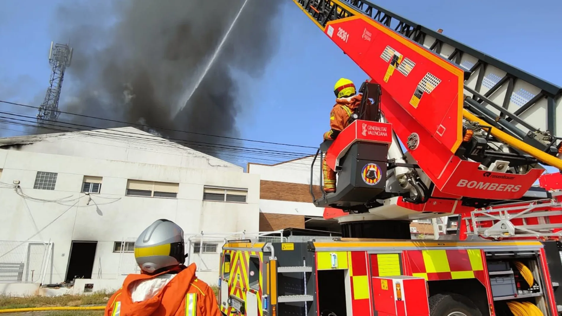 Once dotaciones de bomberos tratan de sofocar el fuego en una nave industrial de Paterna