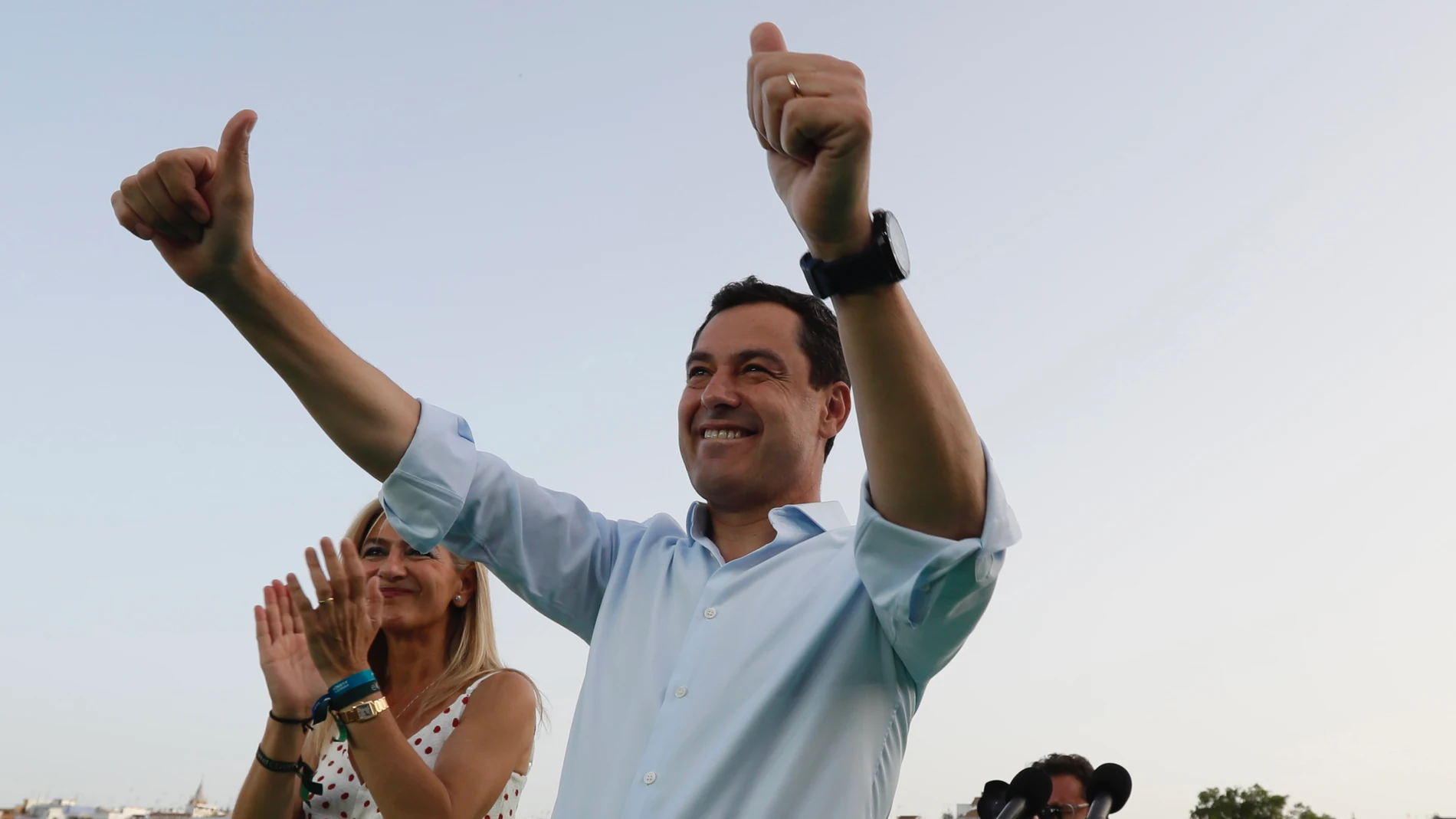 El presidente de la Junta de Andalucía y candidato a la reelección por el PP, Juanma Moreno, saluda al comienzo del acto de cierre de campaña en el Muelle de la Sal en Sevilla. EFE/José Manuel Vidal