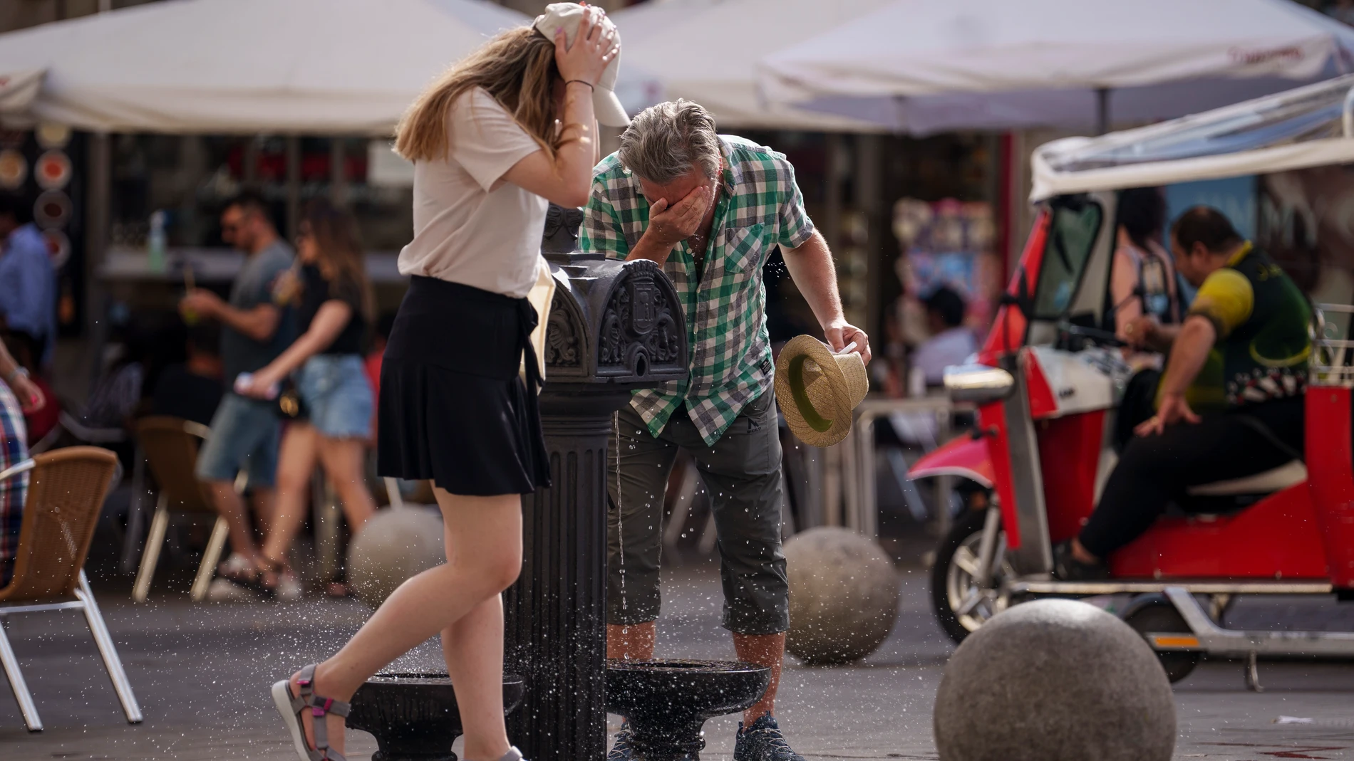 Personas se refrescan en una fuente en plena ola de calor