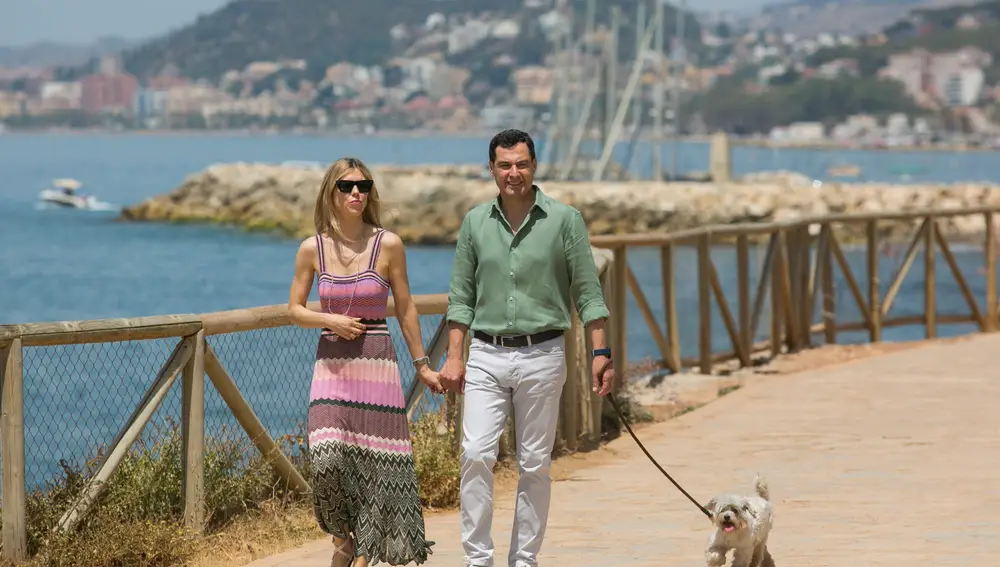 Juanma Moreno, y su mujer, Manuela Villena, pasean a su perro por la Senda Litoral de Málaga, este sábado