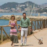 Juanma Moreno, y su mujer, Manuela Villena, pasean a su perro por la Senda Litoral de Málaga, este sábado