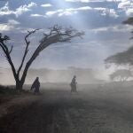 Dos masai cruzan una carretera en el Parque Nacional Serengeti, en Tanzania