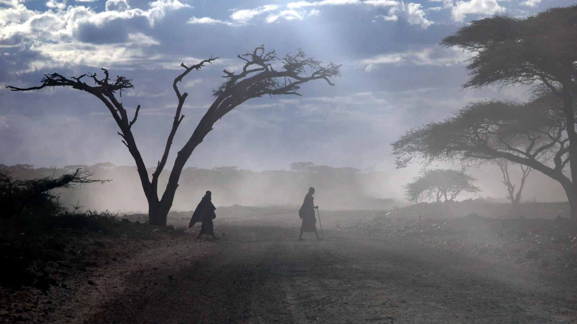 Dos masai cruzan una carretera en el Parque Nacional Serengeti, en Tanzania