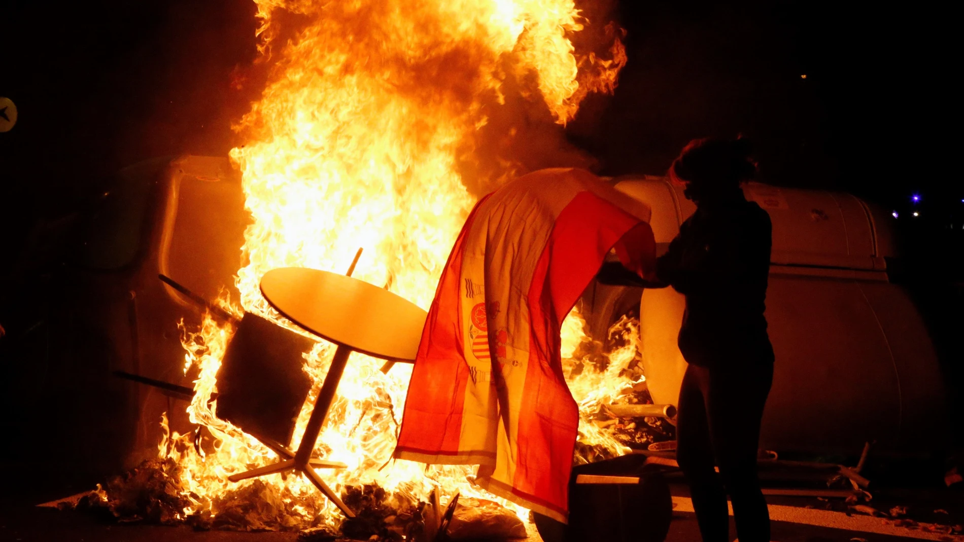 Un manifestante quema una bandera de España durante los altercados tras la concentración convocada por los CDR bajo el lema "Olimpiada Republicana", este jueves en Barcelona.