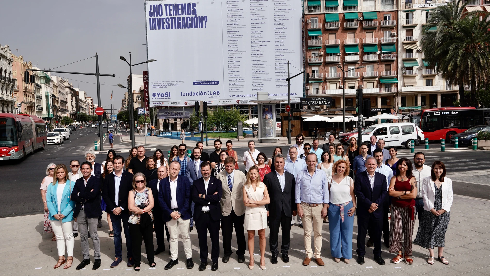 Foto de grupo ante la lona desplegada en la Marina de Valencia