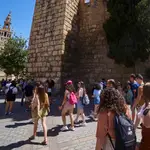 Un grupo de turistas pasa por la Plaza del Triunfo, en Sevilla