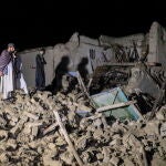 Personal de seguridad y de rescate talibanes inspeccionan una de las casas dañadas tras un terremoto en la aldea de Gayan, en la provincia de Paktia