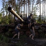 Un hombre examina un tanque ruso destruido en Ucrania