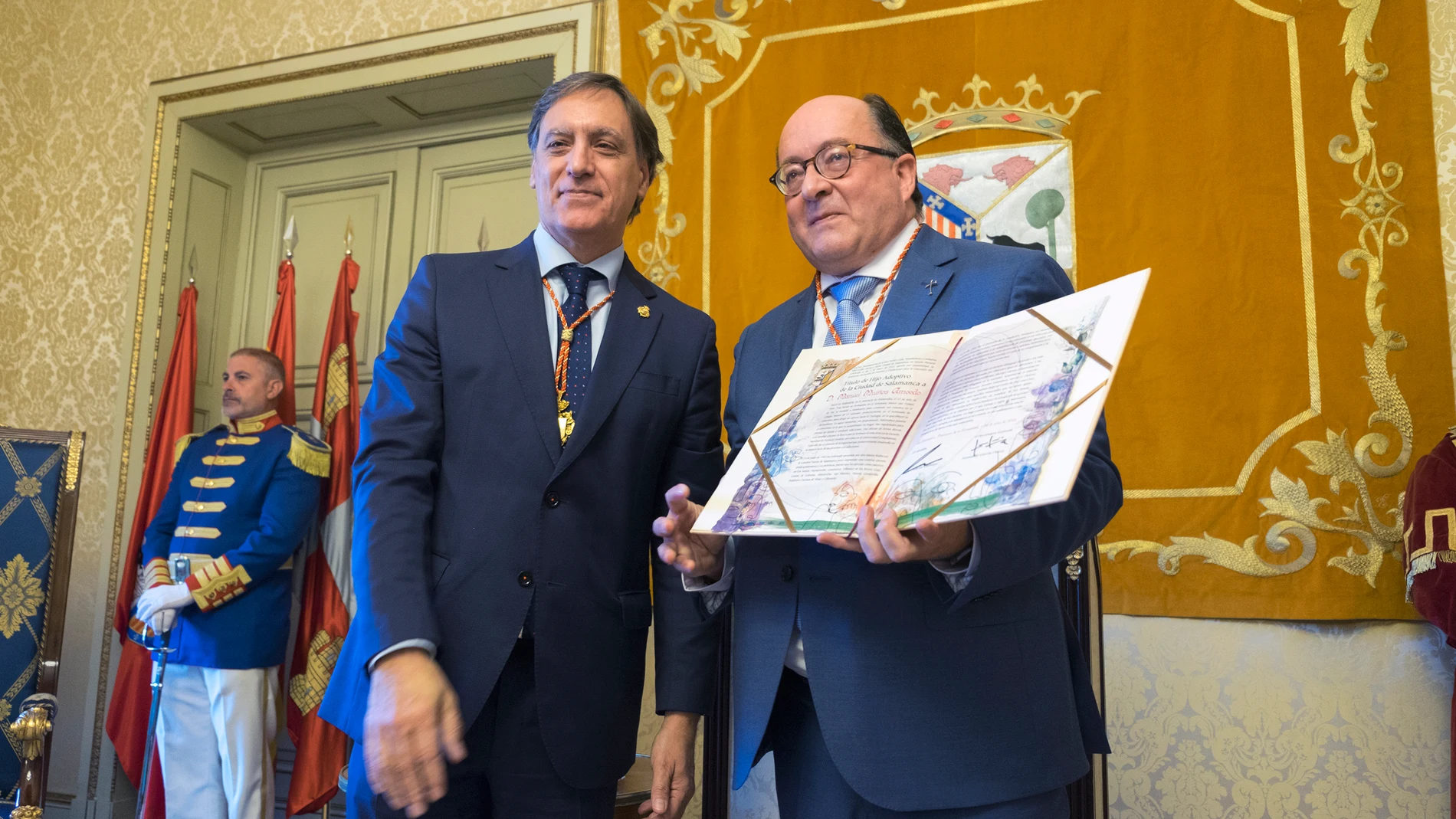 El alcalde de Salamanca, Carlos García Carbayo, entrega del título de Hijo Adoptivo de Salamanca al presidente y fundador de Proyecto Hombre Salamanca, Manuel Muiños