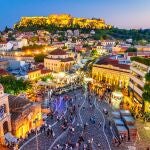 Imagen nocturna con Atenas desde arriba, la plaza Monastiraki y la antigua Acrópolis.