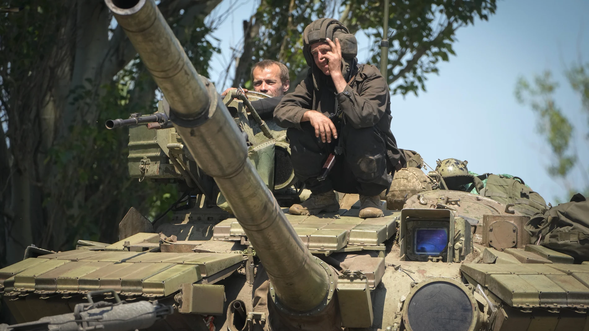 Soldados ucranianos hacen la señal de la victoria sobre un tanque en la región de Donetsk