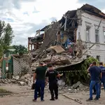 Policías y vecinos junto a un edificio destrozado por un bombardeo ruswo en Kharkiv