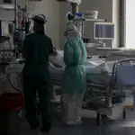 Dos sanitarios atienden a un paciente en la Unidad de Cuidados Intensivos (UCI) dedicada a enfermos de coronavirus del Hospital Universitario Ramón y Cajal, en Madrid.