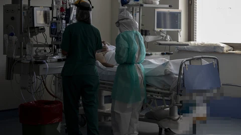 Dos sanitarios atienden a un paciente en la Unidad de Cuidados Intensivos (UCI) dedicada a enfermos de coronavirus del Hospital Universitario Ramón y Cajal, en Madrid.