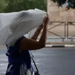 .En la imagen, una mujer se protege de la lluvia durante la tormenta caída hoy en Valencia