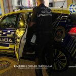 Un agente introduce al detenido en un coche de la Policía Local de Sevilla