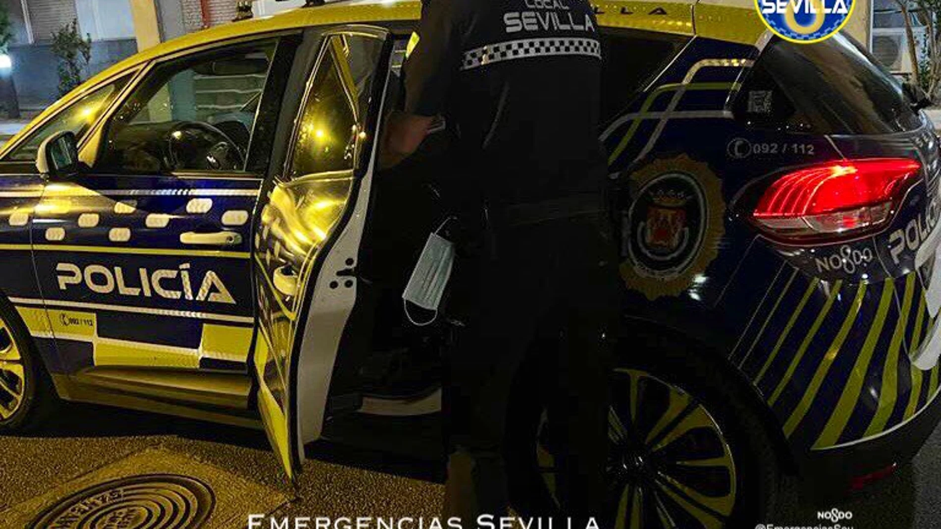 Un agente introduce al detenido en un coche de la Policía Local de Sevilla