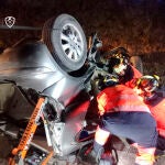 Efectivos del Consorcio Provincial de Bomberos durante la intervención ayer de madrugada en un accidente de tráfico que se ha producido en la carretera A-374, en el que han perdido la vida tres jóvenes, al menos dos de ellos menores, tras huir de un control policial en el término municipal de Ronda (Málaga)