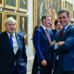 El presidente del Gobierno, Pedro Sánchez (d), conversa con el primer ministro británico, Boris Johnson (i), a su llegada a la cena de la OTAN este miércoles en el Museo del Prado
