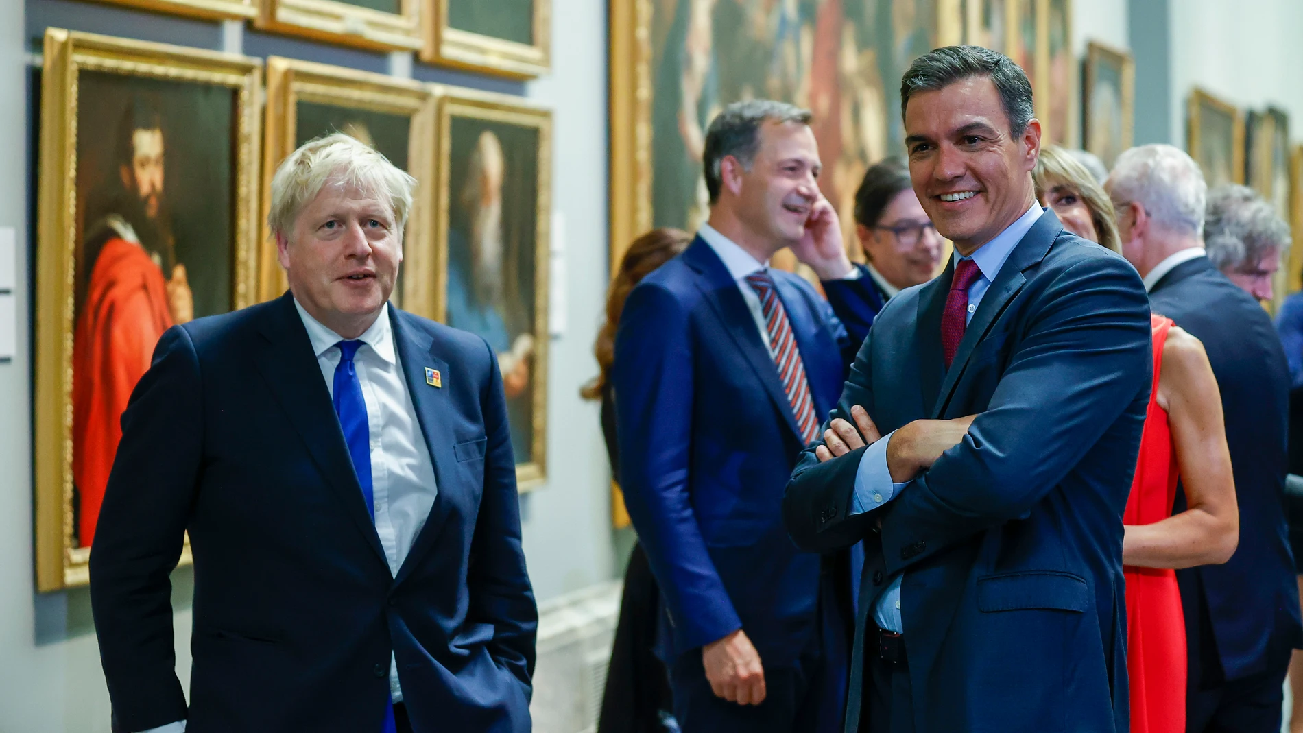 El presidente del Gobierno, Pedro Sánchez (d), conversa con el primer ministro británico, Boris Johnson (i), a su llegada a la cena de la OTAN este miércoles en el Museo del Prado