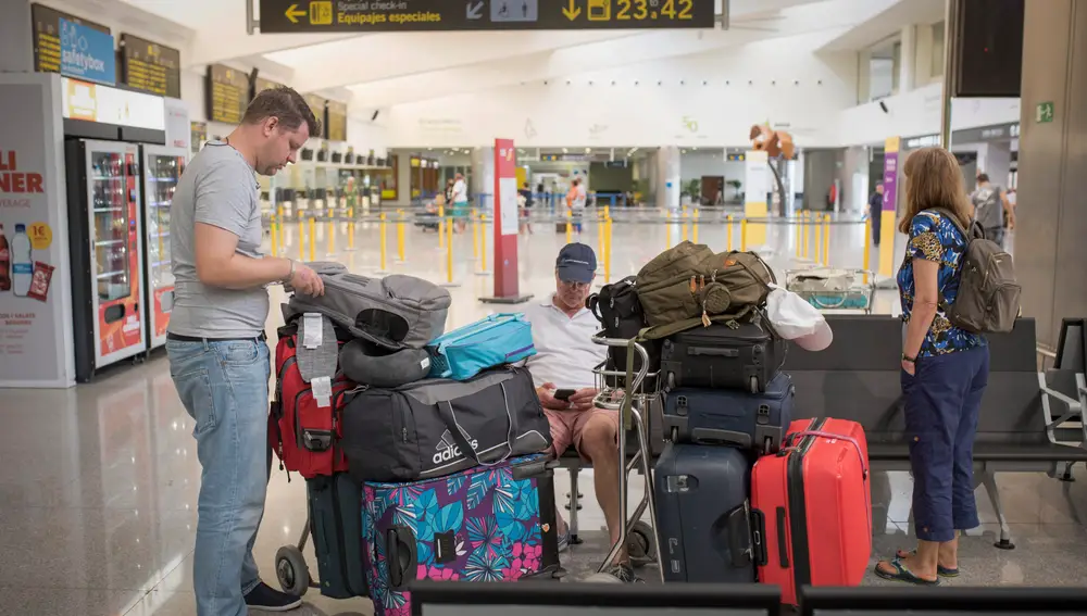 Varias personas en aeropuerto de Menorca antes de partir hacia sus destinos en el primer día del mes de julio de las vacaciones de verano