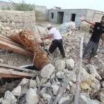 Dos hombres buscan entre los escombros provocados por el fuerte seísmo registrado en la provincia de Hormozgan en el sur de Irán