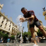 Un hombre se refresca en una de las fuentes del centro de Córdoba en una jornada de intenso calor donde se esperan llegar a los 37 grados