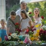 Familias dejan flores en homenaje a las víctimas del bombardeo contra el centro comercial de Kremenchuk, en Ucrania