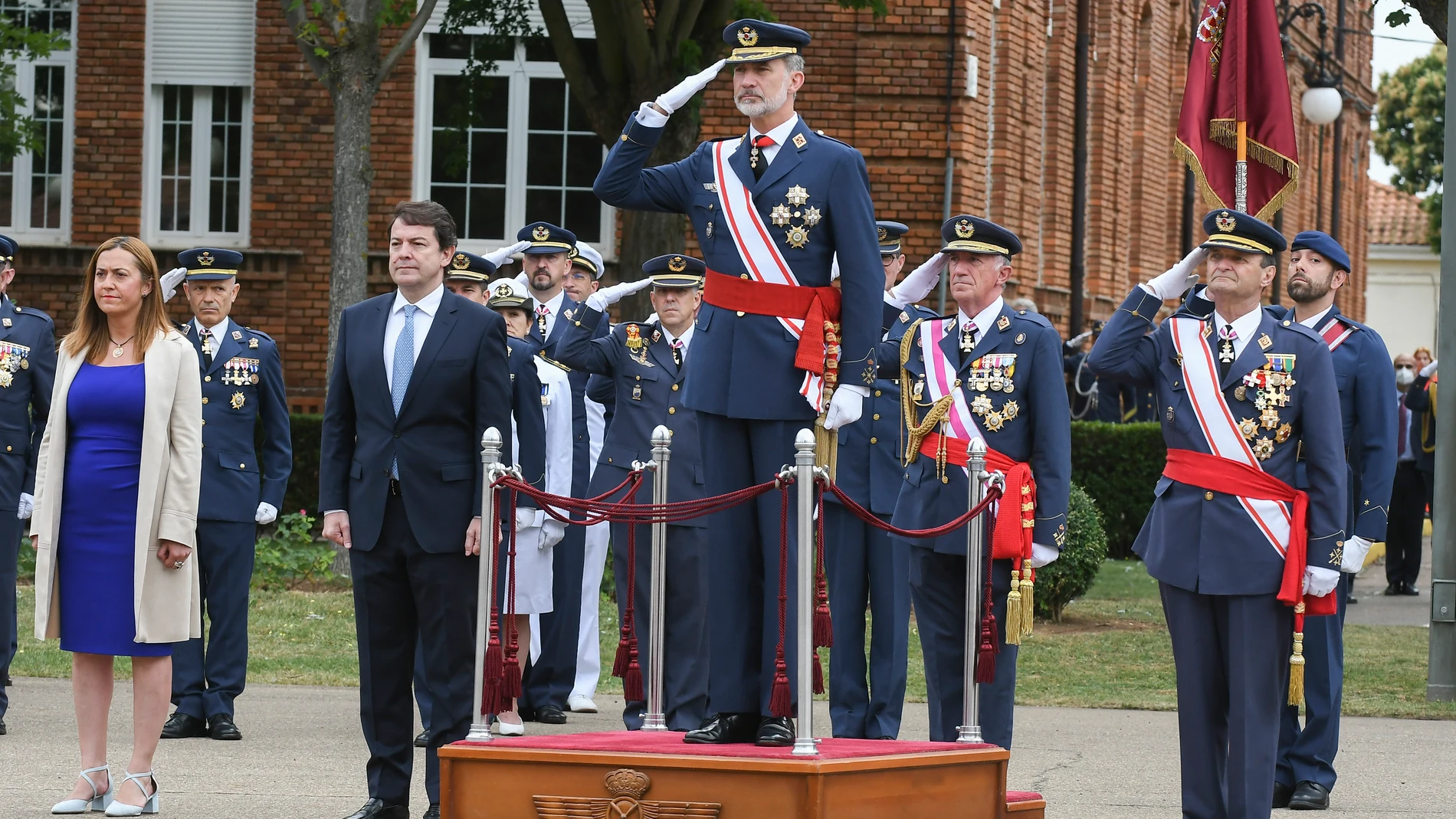 El rey Felipe VI, que preside la entrega de los reales despachos de sargento a la XXX promoción de la Academia Básica del Aire (ABA) de León, escucha el himno acompañado, entre otros del presidente de la Junta de Castilla y León, Alfonso Fernández Mañueco (2i) y la delegada del Gobierno, Virginia Barcones. EFE/J.Casares