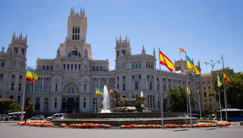 La fuente de la Cibeles y las flores sunpatiens rojas y blancas en el anillo que la rodea