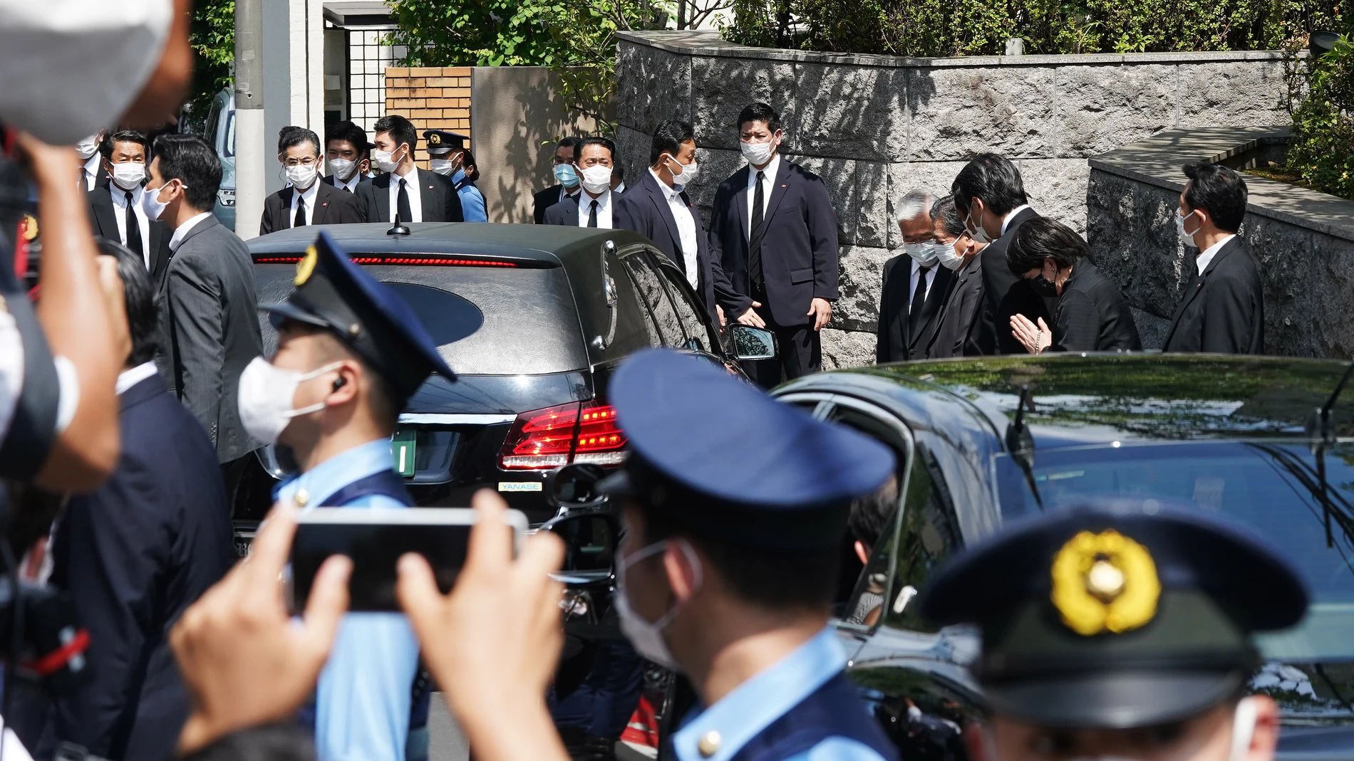 El coche fúnebre que transportaba el cuerpo del ex primer ministro japonés asesinado Shinzo Abe llega a su residencia, mientras su esposa Akie Abe y los miembros principales del gobernante Partido Liberal Democrático se inclinan, en Tokio
