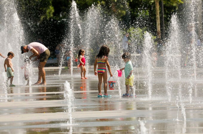 En la imagen, niños y adultos se refrescan en las fuentes del Parque Central de Valencia.